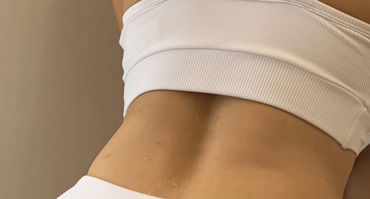 imagen de la espalda de una mujer en la que se resbala el sudor